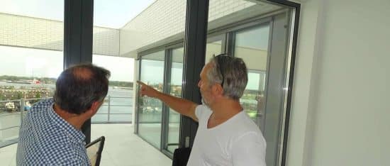 Inspector pointing out a detail at a window to the buyer